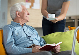 An older adult at home with a book